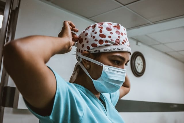 infirmière en train de lacer son masque chirurgical